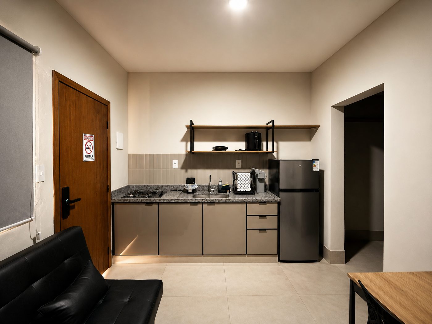 Cozinha compacta com cooktop, pia, geladeira e prateleiras